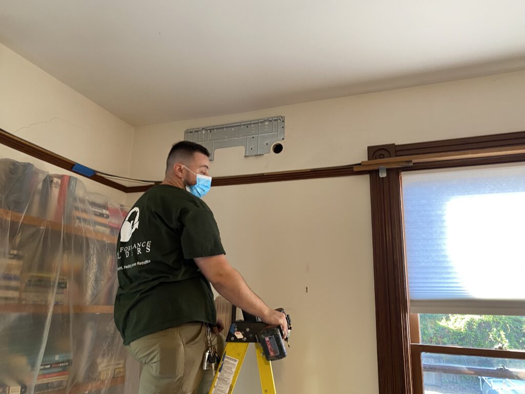 Installing a heat pump wall unit.